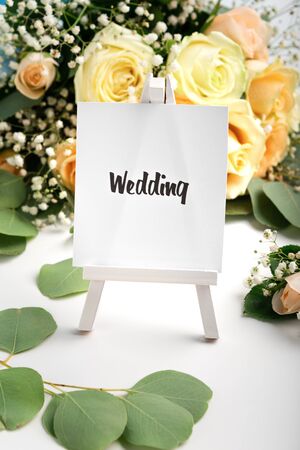 Happy memorable day. Easel with black text on background with cream roses bouquet, vertical panoramaの写真素材