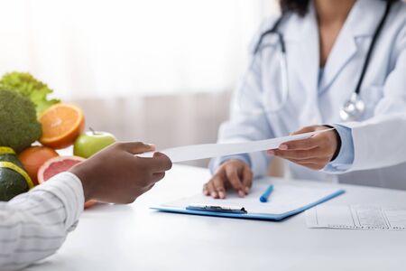 Dietologist giving prescription to client, clinic interior, croppedの写真素材