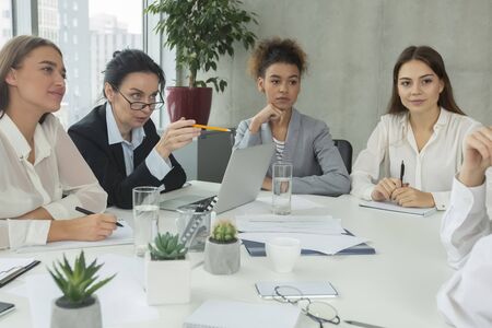 Businesswomen having briefing in office, sharing ideas and discuss work