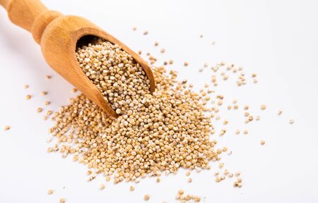 Organic protein sources. Heap of White quinoa and wooden spoon close up, free spaceの写真素材