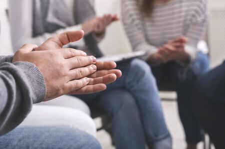 Closeup of people applouding to each other at psychotherapy group meeting, selective focus on male handsの写真素材