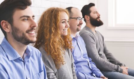 Happy people sitting in a row and listening speaker during workshop, selective focus on woman,...