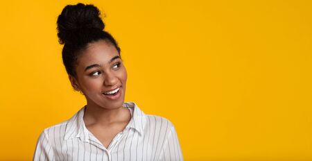 Cool Offer. Curious Black Woman Looking Aside At Copy Space With Interest, Standing Over Yellow Background, Panoramaの写真素材