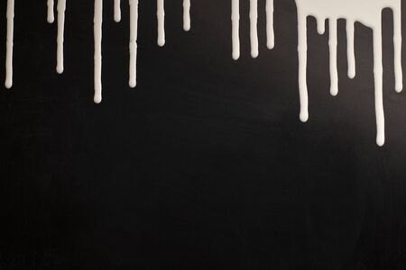 White and black paint colors, colorful acrylic paint dripping on black background, copy space for textの写真素材