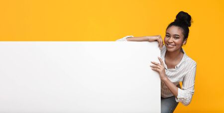 Happy Black Girl Holding White Advertisement Board With Free Space For Your Textの写真素材