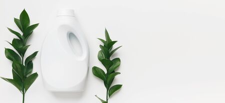 Soft touch. Eco cleaning concept. White plastic washing conditioner with natural components on white...