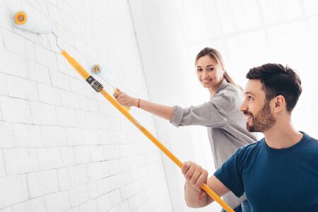 Home Renovation concept. Happy couple painting walls at home, copy spaceの写真素材