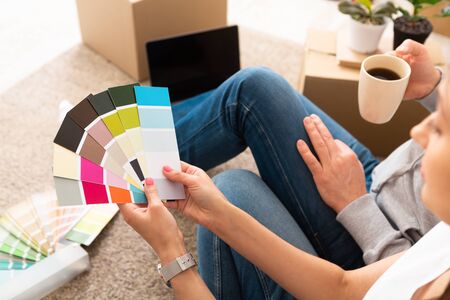 Couple take a break with coffee choose color for walls with palette on moving dayの写真素材