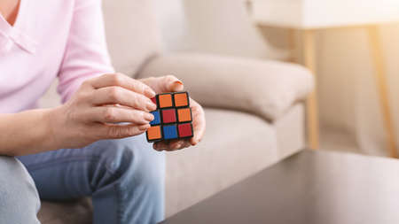 Kharkiv, Ukraine - January 14, 2019: Rubiks cube in hands of mature woman, stay at home concept,...