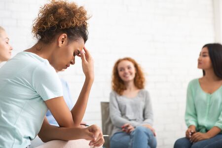 Depressed African Girl Sitting During Female Group Psychotherapy Session Indoors. Selective Focusの写真素材