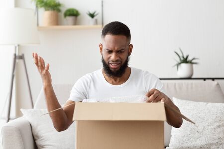 Upset african american millennial man received spoiled delivery of goodsの写真素材