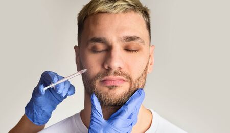 Adult guy takes action against aging in beauty clinic,panorama, free spaceの写真素材