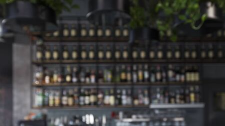 Blurred bar counter with alcohol drinks on shelves, panorama, copy spaceの写真素材