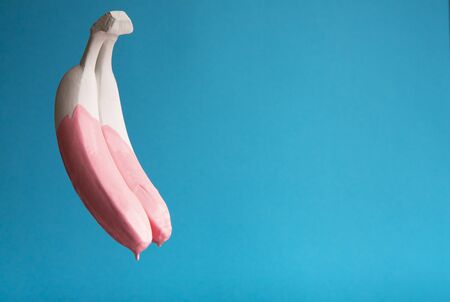From banana dripping pink paint on blue backgroundの写真素材