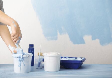 Homemade repair. Girls hand mixes blue paint, free space