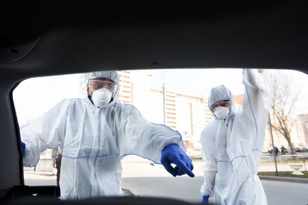 Stop biohazard. Man in coronavirus suit pointing at disinfecting chemicals for cleaning streets,...