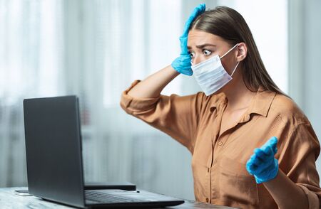 Nervous Reaction. Young woman wearing protective mask and gloves shocked about infectious disease spreadingの写真素材