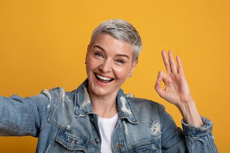 All Is Ok. Cheerful Middle-Aged Woman Taking Selfie And Showing Okay Gesture While Posing Over...