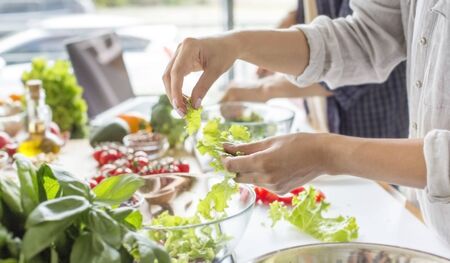 Cooking concept, coolinary, healthy lifestyle. Unrecognizable woman making fresh salad full of vitamins, panoramaの写真素材