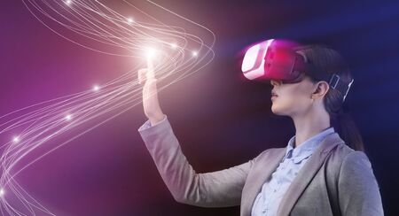 Innovative technologies concept. Businesswoman in VR headset pressing button on virtual screen,...