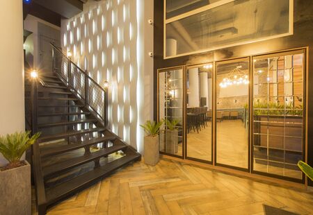 Loft style hall of luxury restaurant with stairs up to second floor, wooden floor, copy space, no...