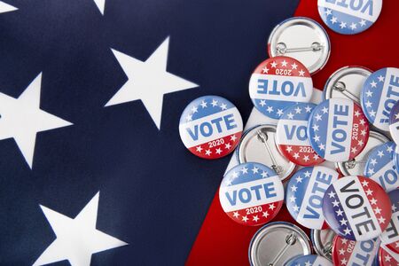Political voting pins for 2020 elections in USA in November on american flag background, copy space