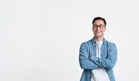 Smiling guy with arms crossed looks at empty spaceの写真素材