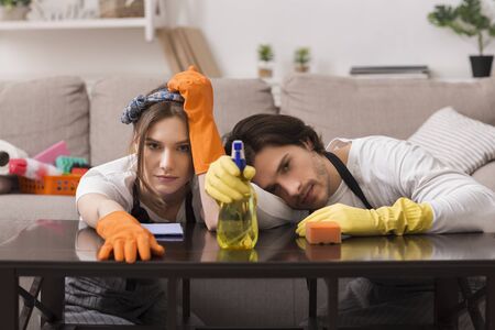 Cleaning Routine. Portrait of tired couple leaning on table, exhausted after tidying flat, free...