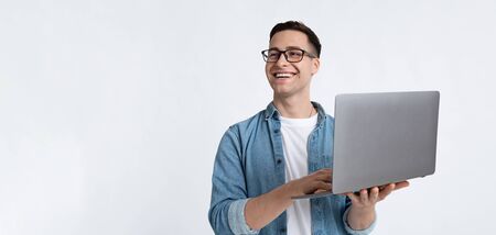 Laughing man in glasses and with laptop, panoramaの写真素材