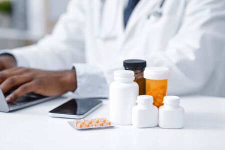 Close up of diverse types of medicine on african doctor table, pills for coronavirus