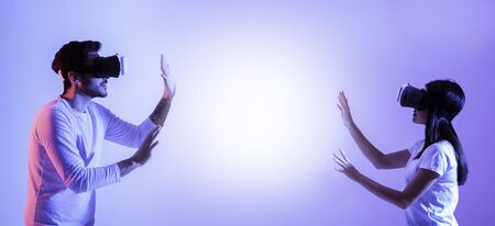 Guy and girl play in virtual reality glasses, panorama