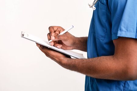 African american doctor hands writing in medical chart, cropped, side view, white background, copy...