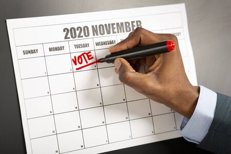 November 2020 presidential elections in USA man writing text reminder on calendar, black backgroundの写真素材