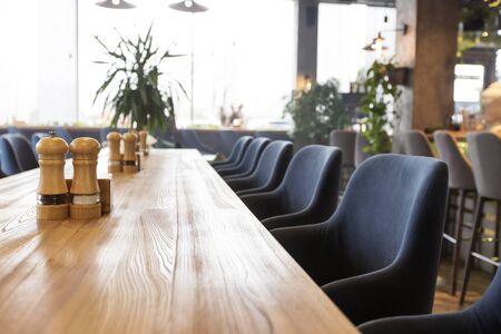 Long table in cafe for coworking, empty interior, no people, copy space