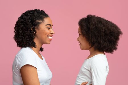 Mother And Child. Side View Portrait Of Happy Afro-American Woman And Her Little Daughter, Looking...