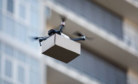 Drone is new tool for delivery, fast and safety air delivery. blurred building on background, copy spaceの写真素材
