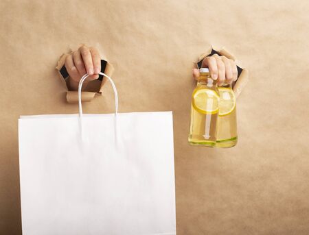 Detox lemonade with infused lemon slices and shopping bag for safety delivery, copy space