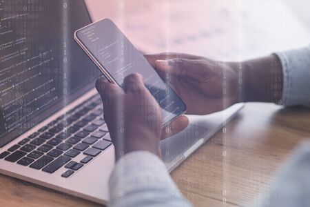 Blockchain technology, IoT concept. Black programmer working on smart phone, laptop with binary computer codeの写真素材