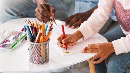Creative hobbies. Closeup of African American child and her granddad drawing with color pencils at home, panoramaの写真素材