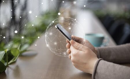 Internet Of Things Concept. Close up of female hands using phone with wireless network connection...