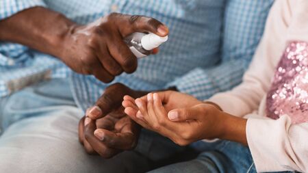 Hygiene during epidemic. Unrecognizable African American grandparent and his grandchild cleaning...