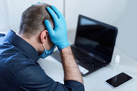 Coronacrisis Concept. Desperate Businessman Sitting At Laptop Touching Head After Fail At Work At...