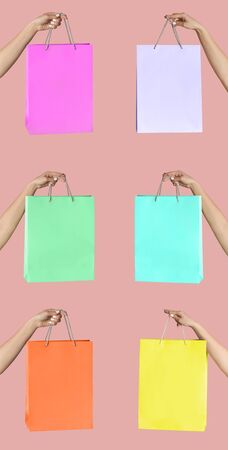 Female hands showing shopping bags of different colors on pink background, vertical collage. Space or designの写真素材