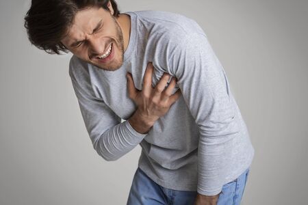 Feeling pain so strong, that man is pressing fingers to chestの写真素材