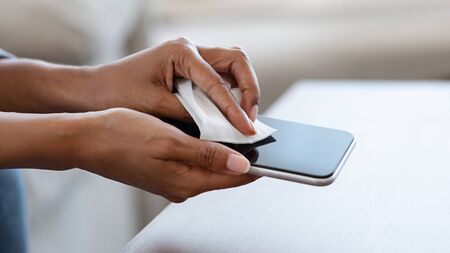 Gadget Disinfection. Unrecognizable Black Woman Disinfecting Smartphone Screen Before Use At Home,...