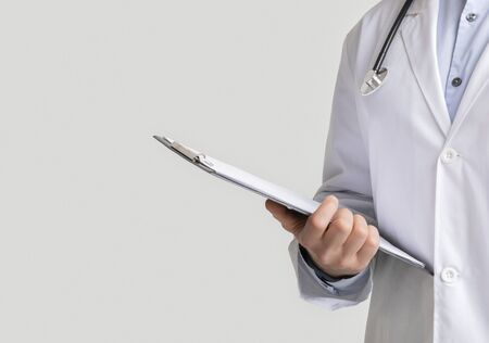 Medical Report. Cropped image of male doctor holding folder with patients data and prescriptions over white studio background, copy spaceの写真素材