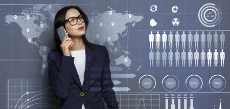 Online business concept. Business lady in 3d glasses talking on phone and looking at interactive charts, grey background, panoramaの写真素材