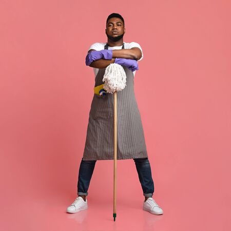 Professional African American Cleaner Posing With Mop Over Pink Background In Studio, Ready For Big Cleaningの写真素材