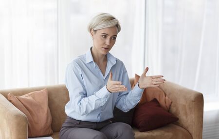 Psychotherapy Concept. Professional Psychologist Giving Advice During Therapy Session Sitting On Sofa In Office.の写真素材