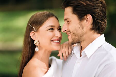 Quarantine Wedding. Smiling Newly-Weds Couple Hugging Looking At Each Other Posing Outdoors During Just Us Ceremony Without Guests.の写真素材